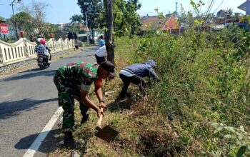 Babinsa Pandanrejo, Serda Bambang Setiono, bersama warga dan perangkat desa membersihkan TPU Dusun Pandan.