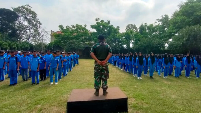 Peltu Cahyo, Batuud Koramil 0818/19 Gondanglegi, memberikan pengarahan dengan tegas di depan ribuan siswa-siswi SMK MUTU Gondanglegi yang berbaris rapi.