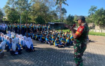 Babinsa dari Koramil 0818-04/Ngantang memimpin pembukaan kegiatan Latihan Baris-Berbaris di lapangan SMP Negeri 1 Ngantang, dengan siswa-siswi berbaris rapi di hadapannya