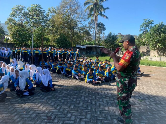 Babinsa dari Koramil 0818-04/Ngantang memimpin pembukaan kegiatan Latihan Baris-Berbaris di lapangan SMP Negeri 1 Ngantang, dengan siswa-siswi berbaris rapi di hadapannya