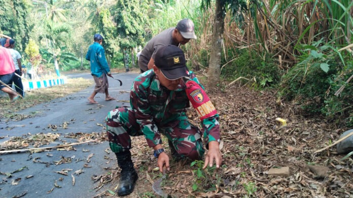 Babinsa Dampit bersama warga melakukan karya bakti membersihkan jalan di Polaman