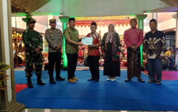 Serka Warosin, Babinsa Genengan, sedang duduk di pendopo Desa Genengan saat menghadiri acara wayang kulit dalam rangka "Bersih Desa Genengan".