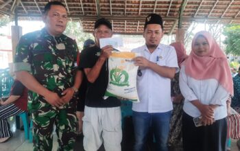 Babinsa Desa Mojosari Serka Susminto dari Koramil 0818-05/Kepanjen membantu mendistribusikan beras bantuan pangan kepada warga Desa Mojosari.