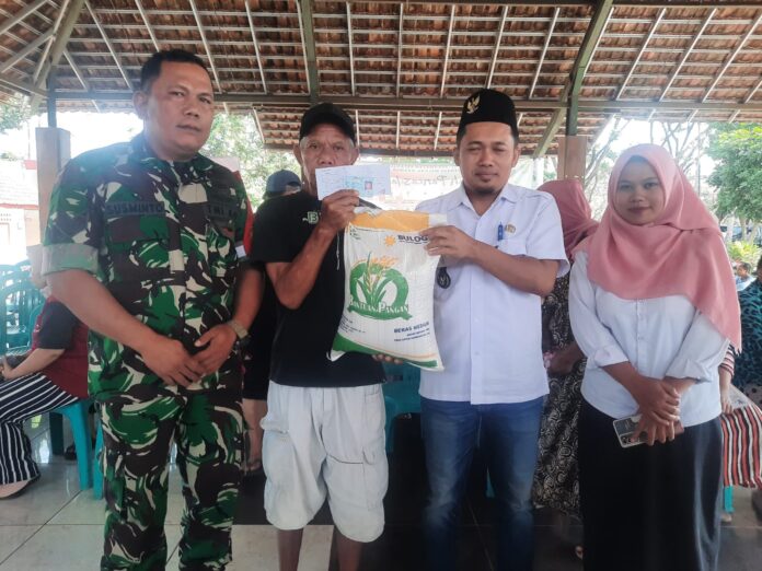 Babinsa Desa Mojosari Serka Susminto dari Koramil 0818-05/Kepanjen membantu mendistribusikan beras bantuan pangan kepada warga Desa Mojosari.