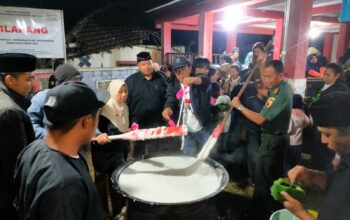 Danramil Batu dengan pakaian dinas militer sedang mengaduk jenang suro dalam acara Peringatan 1 Suro 1958 di Songgokerto.