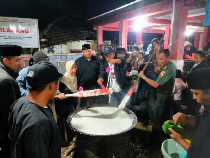 Danramil Batu dengan pakaian dinas militer sedang mengaduk jenang suro dalam acara Peringatan 1 Suro 1958 di Songgokerto.