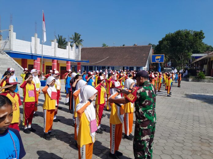 Babinsa Sukodadi sedang memberikan instruksi pada siswa SMPN 2 Wagir dalam pelatihan baris berbaris.