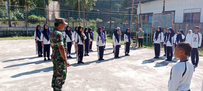 Babinsa Sukomulyo memimpin Latihan Baris Berbaris di lapangan SMP PGRI 1 Pujon