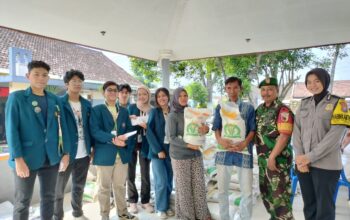 Babinsa, Bhabinkamtibmas, petugas distribusi, dan warga berfoto bersama di depan Balai Desa Kemantren setelah acara pembagian Beras Bulog.