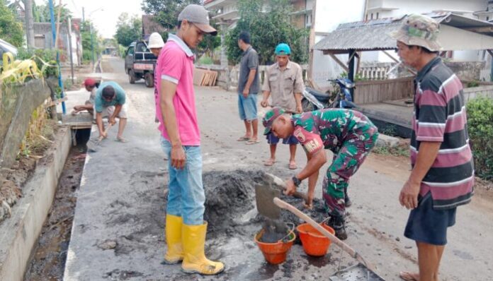 Serda Suwebin, Babinsa Senggreng, bersama warga Desa Senggreng bergotong royong membangun jalan desa