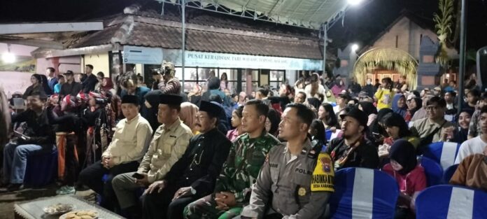 Serda Sudarno, Babinsa Karangpandan, bersama Kepala Desa dan warga membersihkan dusun dalam kegiatan melestarikan Tari Topeng Malangan.