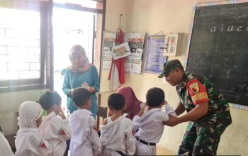 Babinsa Kepanjen Serda Abd. Faruk mendampingi kegiatan imunisasi anak di SD Negeri 1 Kepanjen