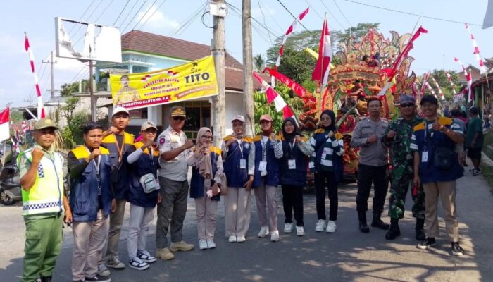 "Foto bersama mahasiswa KKN di lokasi kegiatan, semua tersenyum lebar di depan latar belakang desa."