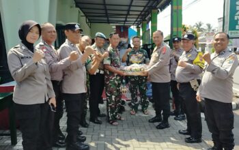 Kapolsek Ngajum dan anggota TNI merayakan HUT TNI ke-79 dengan tumpeng dan kehadiran masyarakat serta instansi lokal.