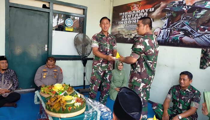 Prajurit termuda Koramil 0818-09 Ngajum memberikan tumpeng sebagai simbol penghormatan dalam perayaan HUT TNI ke-79