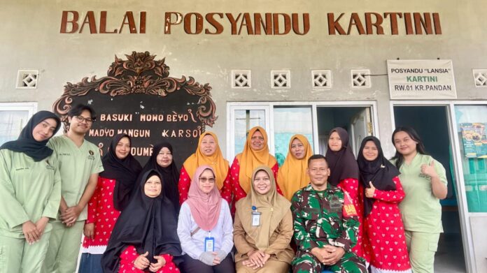 “Babinsa Karangpandan Serda Sudarno mendampingi kegiatan posyandu di desa binaan untuk mencegah stunting sejak dini.”